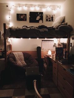 a dorm room with lights strung from the ceiling and a bed on top of it