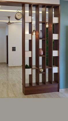 a clock is on the wall next to a bookcase with shelves and vases