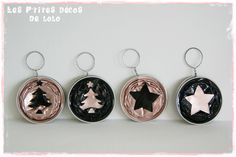 three metal keychains with different designs on them, one has a star and the other has a tree