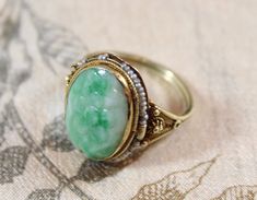 -Antique Chinese 14k Gold Filigree Carved Flower Natural Jadeite Seed Pearl Ring -Ring size: 5.75US -Jadeite size: 10.55 mm x 15.5 mm -Total weight: 3.7 g -Marked 14k -Some pearls are missing Vintage Green Filigree Ring With Gemstone, Vintage Green Oval Filigree Ring, Green Vintage Oval Filigree Ring, Vintage Jade Jewelry For Anniversary, Antique Jade Jewelry For Anniversary, Jade Cabochon Jewelry For Wedding, Green Oval Filigree Ring For Wedding, Seed Pearl Ring, Coral Bracelet