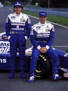 two men sitting on top of a racing car