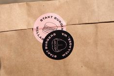 a brown paper bag with two stickers on the front and back of it that says stayktt burgers