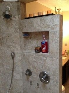 a bathroom with a walk in shower next to a sink and toilet paper dispenser