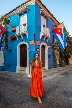 a woman standing in front of a blue building