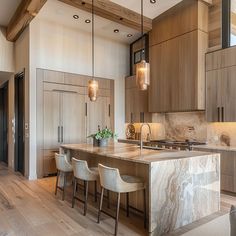 a large kitchen with wooden cabinets and marble counter tops, along with bar stools