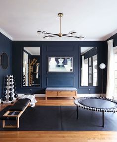 a living room with blue walls and wooden flooring in the center is a round black table