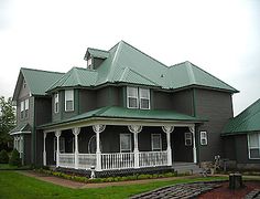 a large house with green roof and white trim