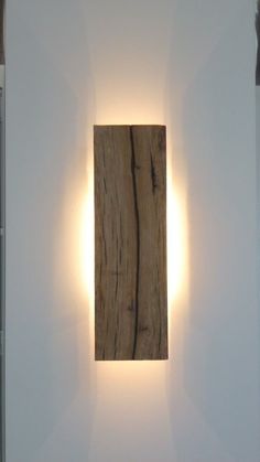 a white wall with a wooden light on it