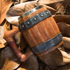 a wooden mug sitting on top of leaves