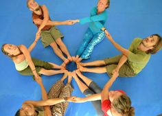 a group of young women standing in a circle with their hands on top of each other