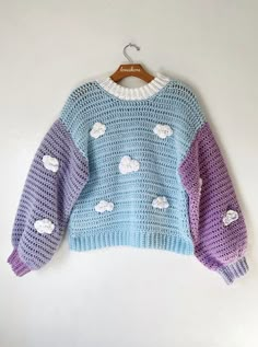 a blue and purple sweater with clouds on it