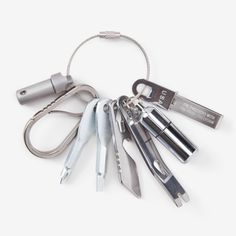 a bunch of tools that are on a white surface with a keychain attached to it