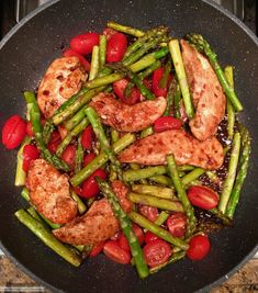 chicken, asparagus and cherry tomatoes in a skillet