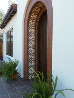 an entrance to a house with plants in the foreground