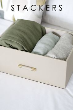 two pillows in a white box on a bed with the words stackers above it