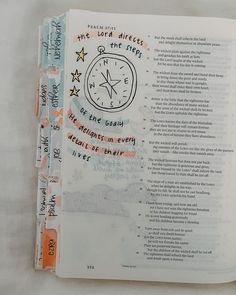 an open book with writing on it and a clock drawn on the page in red