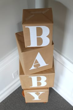 three cardboard boxes stacked on top of each other with the letters baby printed on them