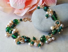 "Elegant, Opulent and Shimmery. This gorgeous cluster bracelet is jam-packed with clusters of small ivory freshwater pearls and emerald crystals. Eight beautiful faceted emerald green Swarovski crystals in the center. This bracelet is adjustable from 7\" to 8\" and is finished with a secure gold lobster claw clasp. This stunning cluster bracelet is unique, feminine and eye-catching, Perfect for anyone that wants to make a statement or to wear to a special occasion! Also available in sterling sil Emerald Green Crystal, Cluster Bracelet, Cluster Bracelets, Small Bracelets, Pearl Cluster, Bead Bangles, Ivory Pearl, Green Crystal, Seed Bead Bracelets