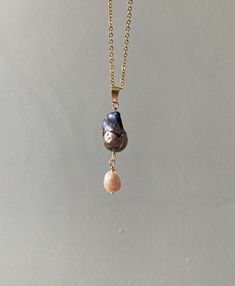 Iridescent, rainbow shifting black flameball pearl pendant, suspending a palest pink pearl teardrop. On an 18inch 18k gold plated chain necklace.  Unique, one of a kind Gold Baroque Pearl Drop Necklaces, Gold Baroque Pearl Teardrop Pendant Necklace, Gold Dangle Charm Necklace With Pearl Drop, Drop Pearl Pendant Necklace, Baroque Pearl Drop Necklace With Pearl Pendant, Teardrop Pearl Chain Necklace, Teardrop Baroque Pearl Jewelry With High Luster, Gold Teardrop Pearl Drop Necklace, Long Drop Pearl Pendant Necklace