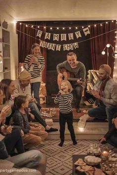 a group of people that are sitting in front of a fire place and some lights