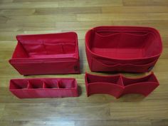 four pieces of red leather sitting on top of a wooden floor