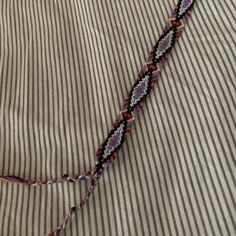 a close up of a piece of cloth on a bed with pinstripe and thread