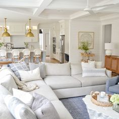 a living room filled with white furniture and lots of pillows on top of it's couches