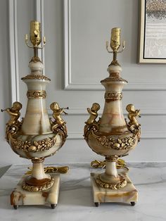 two fancy vases sitting next to each other on top of a marble countertop