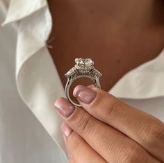 a close up of a person holding a ring with a diamond in it's center