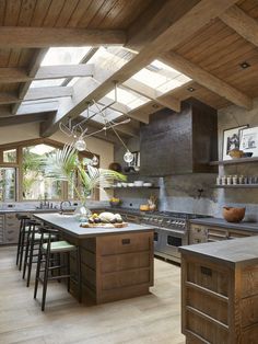 an open kitchen with wooden floors and skylights