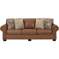 a brown leather couch with pillows on it