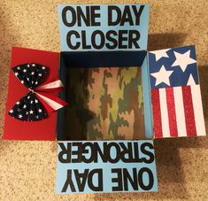 an open box with the words, one day closer and two american flags on it