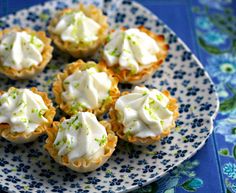 small cupcakes with white frosting and green sprinkles on a plate