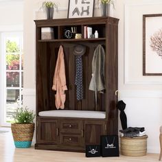 a wooden coat rack with several coats hanging on it's sides and two doors open