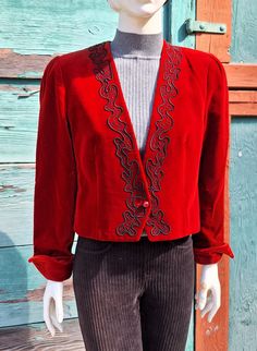 This lovely Bolero-style jacket has great equestrian flare, so lovely over a crisp white blouse and your black breeches/boots for that special evening at the horse show or other equestrian event. 100% cotton velvet in a rich shade of red brick with tonal acetate lining, single button front and black soutache along front placket; no collar, lightly structured shoulders, split cuffed sleeves, nipped waist, cropped cut. Label is Jaeger, a British brand that was founded in 1884 and became world-reno Vintage Red Party Blazer, Elegant Spring Costume Outerwear, Vintage Outerwear For Evening In Fall, Vintage Fall Costume Outerwear, Vintage Fall Blazer For Parties, Vintage Red Outerwear For Evening, Vintage Fitted Blazer For Fall, Vintage Blazer For Fall Party, Vintage Fitted Outerwear For Costume