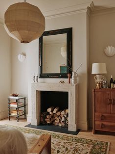 a living room filled with furniture and a fire place under a mirror on the wall