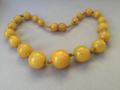 "Lovely egg yolk Bakelite single strand necklace. Hand tied graduated beads. Romantic, yellow necklace. Hidden bead clasp. Simply beautiful, gleaming, set of beads. Large knot, hand tied 1930s style. Chunky! Graduated beads: 8mm (smallest) to 17mm (largest) 15 1/2\" necklace Attention: All items are listed to the best of our observation, but they are pre-owned and pre-loved (meaning we may have missed something minor and/or be in need of light cleaning.) Please read our shop policies and/or conv 1930s Style, 2 Necklace, Yellow Necklace, 1930s Fashion, Egg Yolk, Gold Hands, Freshwater Pearl Necklaces, Strand Necklace, Simply Beautiful