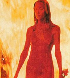 a woman standing in front of a fire