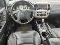 the interior of a car with black leather seats and dash board, steering wheel and dashboard controls