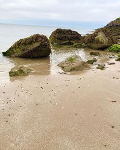 some rocks in the sand and water