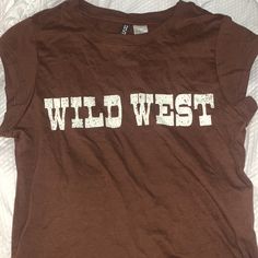 Xs Brown Wild West T-Shirt. Never Worn With Tags! Brown Cotton Tops With Logo Print, Trendy H&m Graphic Print T-shirt, Brown Graphic Tee With Text Print, Brown Text Print T-shirt For Summer, Casual Brown T-shirt With Text Print, Brown Letter Print Top For Summer, Brown Crew Neck Top With Letter Print, Casual Brown Tops With Text Print, H&m Crew Neck T-shirt With Letter Print