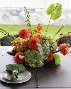 an arrangement of flowers and greenery on a table