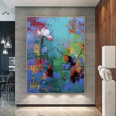 an abstract painting hangs on the wall next to a dining room table