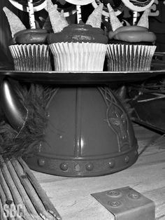 cupcakes and other pastries are displayed on a cake platter in black and white