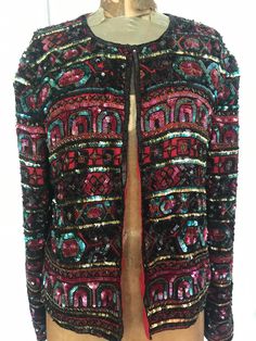 "Festive sequin silk jacket; padded shoulders, long sleeves, one tiny hook at the neck. Red  lining; made in India, size large. Papell Boutique Shoulder seam to wrist 24 1/2\" Neck to waist 22\" Armpit to armpit 19\" Great condition, inside and out SHOP THE STORE:  https://www.etsy.com/shop/BrocanteBedStuy?" Embellished Red Outerwear For Fall, Red Embellished Outerwear For Fall, Red Long Sleeve Sequined Outerwear, Red Sequined Outerwear For Party, Red Embellished Winter Outerwear, Red Embellished Outerwear For Party, Red Festive Outerwear For Party, Festive Red Outerwear For Party, Red Embellished Party Outerwear