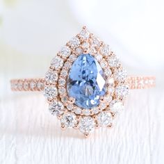 an oval shaped blue diamond surrounded by smaller round diamonds