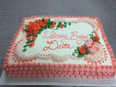 a sheet cake decorated with roses and the words welcome baby delta on it's side