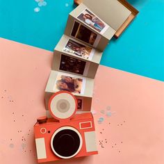 an orange camera sitting on top of a pink and blue floor next to a wall