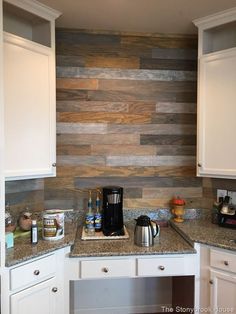 a kitchen with white cabinets and wood wallpaper on the backsplash is shown