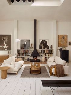 a living room filled with furniture and a fire place in the middle of a room